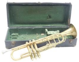 An early 20thC brass trumpet, with stippled decoration, cased.