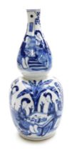 A Qing dynasty blue and white porcelain double gourd vase, decorated with women seated in a garden s