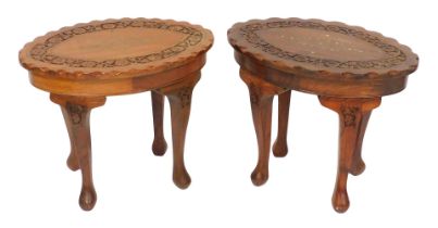 A pair of Chinese hardwood oval occasional tables, with floral carving and brass inlay, raised on ca