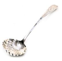 A George III Irish silver cream ladle, with a scalloped bowl, the terminal with bright cut engraving