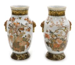 A pair of Taisho period Japanese porcelain vases, with lion's head and ring handles, decorated with