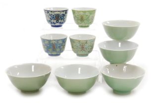 Four 20thC Chinese porcelain wine cups, decorated with lotus flowers and calligraphy, on vari-colour