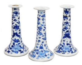 A pair of Qing dynasty blue and white porcelain candlesticks, of outswept form, decorated with birds
