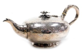 A Victorian silver teapot, of circular form, with a scroll handle and floral knop lid, foliate engra