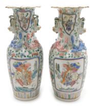 A pair of 19thC Cantonese famille rose porcelain vases, with a frilled neck and lion dog handles and