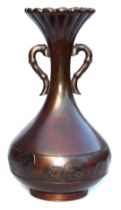 A Meiji period bronze vase, of fluted, and twin handled, baluster form, the body with a band embosse