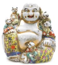 A 20thC Chinese porcelain figure of a happy Buddha, modelled seated with five children, bears paper