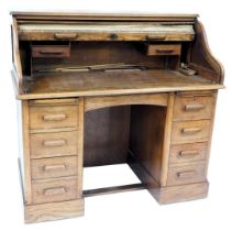 A Lebus oak clerk's desk, with a tambour front opening to reveal drawers and recesses, over twin ped