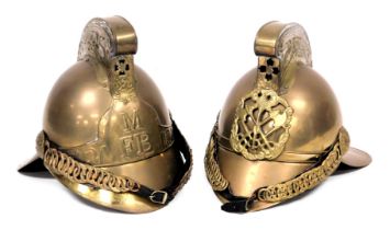 Two replica brass fireman's helmets, 26cm high.