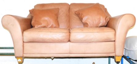 A two seater tan leather sofa.