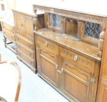 An oak court cupboard, with two glazed doors over two drawers above two panelled doors, a linen pres