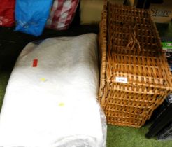 A wicker picnic basket and a quantity of textiles.