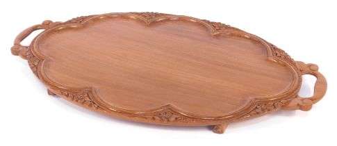 An early 20thC Anglo Indian twin handled hardwood tray, of oval form, with foliate carving, 60cm wid