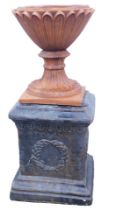 A terracotta planter or urn, of hourglass form, on a square base, 35cm high, together with a painted