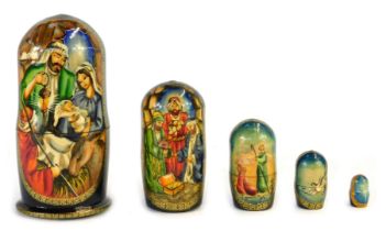 A Russian doll, formed of five painted nativity scenes, with star centre, dove, two shepherds, three