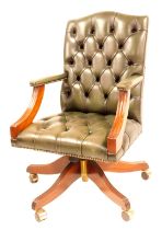 A green leather button upholstered reproduction mahogany swivel chair.