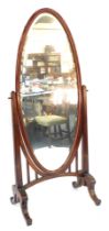 A Continental red lacquered cheval mirror, of oval design, on a stained hardwood frame, 190cm high,