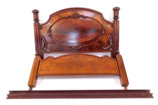 A Victorian figured mahogany bed head and foot, the bed head with arched top and with central oval p