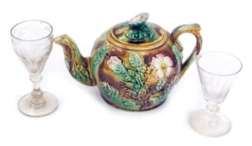 A late 19thC majolica teapot, moulded with apple blossom, together with two 19thC wine glasses. (3)