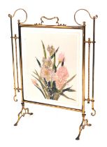 A late Victorian brass and glass panelled fire screen, with scroll framework supports and a painted