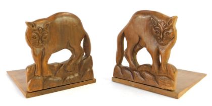 A pair of mid century hardwood bookends, each with carved wild cat end, 18cm high, 14cm wide. (2)