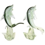 A pair of Murano glass dolphins, each on a grey, black and white ground, riding a wave, 38cm high.