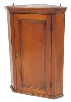 A George III oak hanging corner cabinet, with single fielded panelled door and a fitted interior, 96