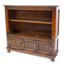 A reproduction oak open bookcase, with one adjustable shelf above arrangement of two cupboards, on s