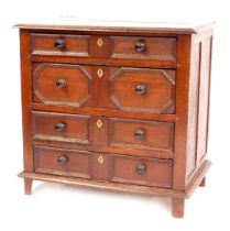 A late 17thC oak chest, of four graduated drawers, with later knop handles and brass key plates, on