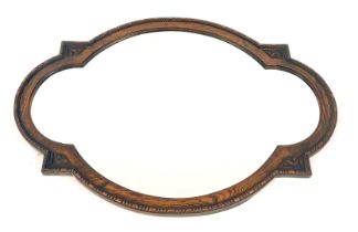 A 1920s oak framed wall mirror, of shaped oval design with a beaded border, 73cm high, 100cm wide.