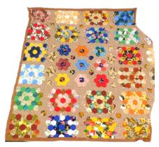 A patchwork quilt, with a brown material border, and hexagonal patchwork sections, approx 220cm x 25