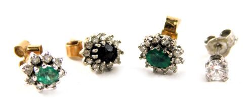 Four single stud earrings, comprising a diamond stud, two emerald and diamond cluster, unmatched, an