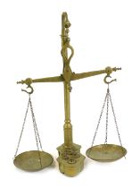 A set of brass balancing scales, with weights, on an integral base, 55cm high.