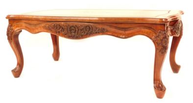 An Oriental hardwood coffee table, of rectangular form with shaped and fluted borders, with floral s