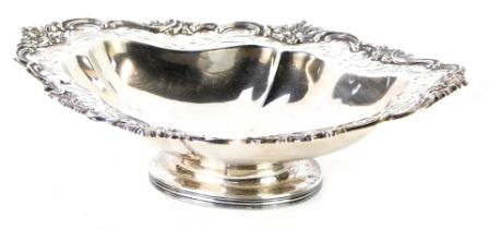 An Edward VII silver oval pedestal dish, with shell capped and reeeded scroll border, on a pierced r