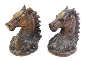 A pair of late 19thC oak carvings of horse's heads, each carved with a jagged collar and cross motif