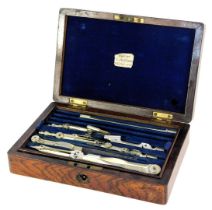 An early 20thC rosewood box, containing drawing instruments, the hinged lid enclosing a section cont