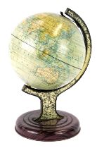 A tabletop miniature globe, tinplate on an arched and moulded base, 21cm high.