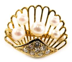 An oyster shell brooch, of pierced design set with five cultured pearls, and set with tiny diamonds