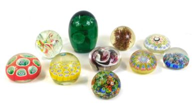 A collection of glass paperweights, comprising five millefiori cane weights, a green glass dump with
