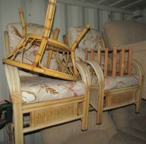 A group of caned conservatory furniture, comprising two armchairs and a table, together with a wine