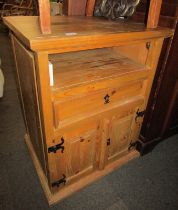 A pine side cabinet, with a recess above a drawer above two panelled doors, 84cm high, 64cm wide, 54