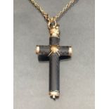 Pendant cross with gold detailing and containing a gold propelling pencil, on a long Gold chain