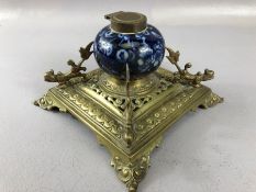 French Brass and blue and white ceramic inkwell on four splayed feet, the ceramic pot decorated with