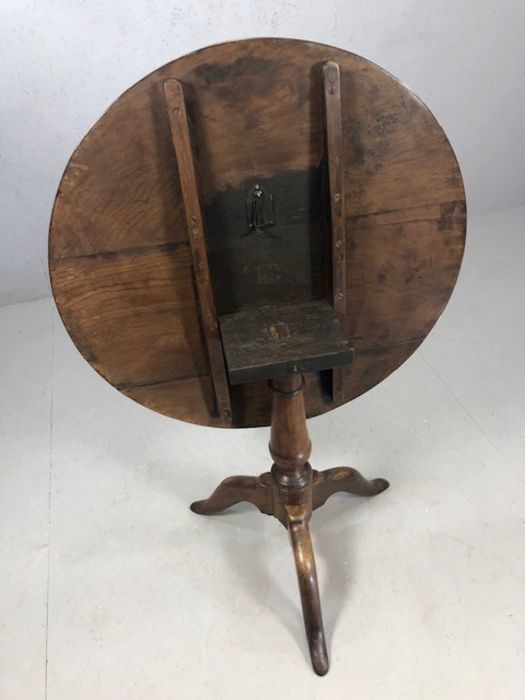 Circular tilt top table on tripod feet with turned central column, approx 74cm in diameter - Image 5 of 6