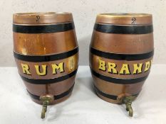 A pair of stoneware barrels each with brass pouring spout, labelled Rum and Brandy, each approx 33cm