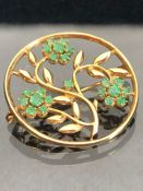 9ct Gold brooch with open work flowers and leaves set with green gemstones approx 28mm in diameter