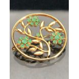 9ct Gold brooch with open work flowers and leaves set with green gemstones approx 28mm in diameter