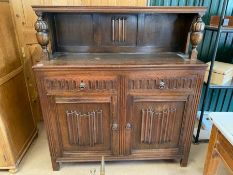 Small, carved, dark wood sideboard with shelf above, two drawers and shelving under
