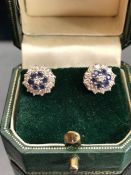 18ct Gold earrings in a Daisey style set with a central diamond surrounded by six blue sapphire